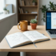 Moderner Schreibtisch mit aufgeschlagenem Notizbuch voller handgezeichneter CRM-Diagramme, Laptop mit Dashboard, Kaffeetasse und Pflanze.
