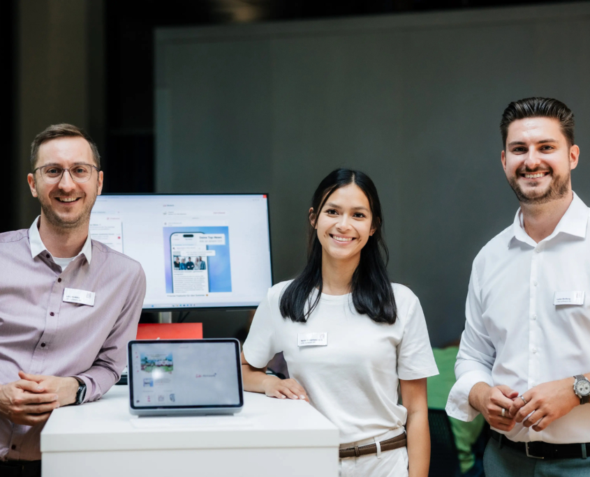 Aufnahme einer weiblichen und zwei männlicher CAS- Mitarbeiter an einem Messestand mit Stehtisch des Customer Centricity Forums 2026.