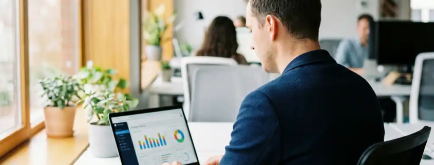 Marketingprofi analysiert Kunden-Analytics-Dashboard auf Laptop im modernen Büro mit natürlichem Seitenlicht.